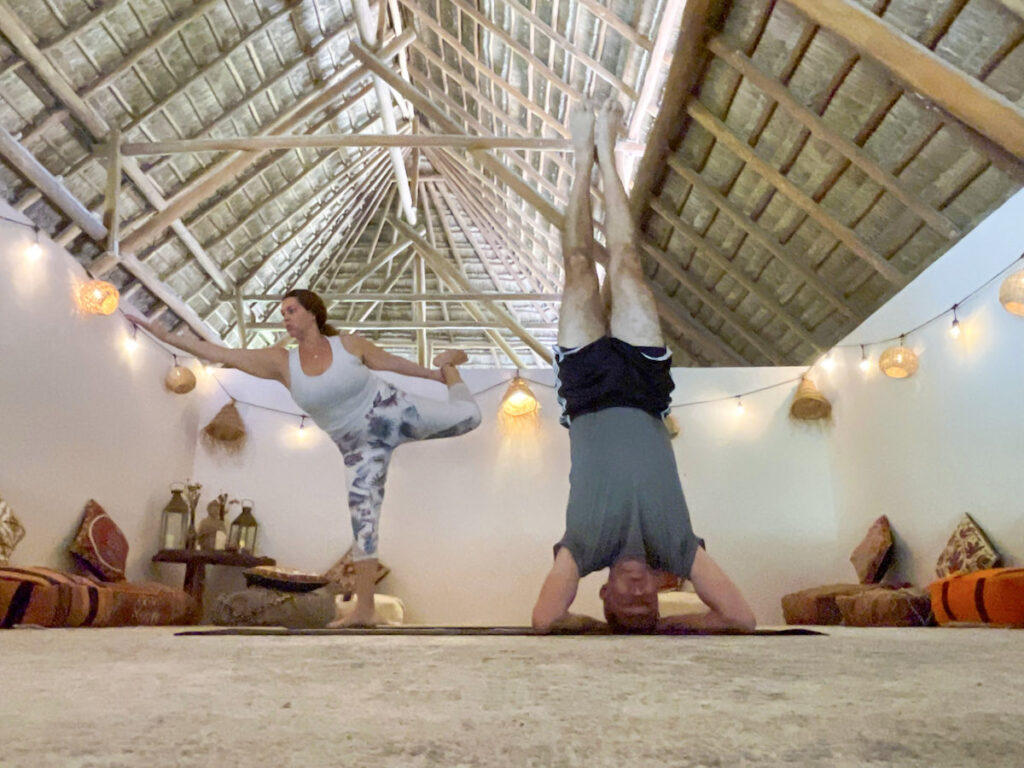 A woman balancing on one leg and a man doing a headstand.