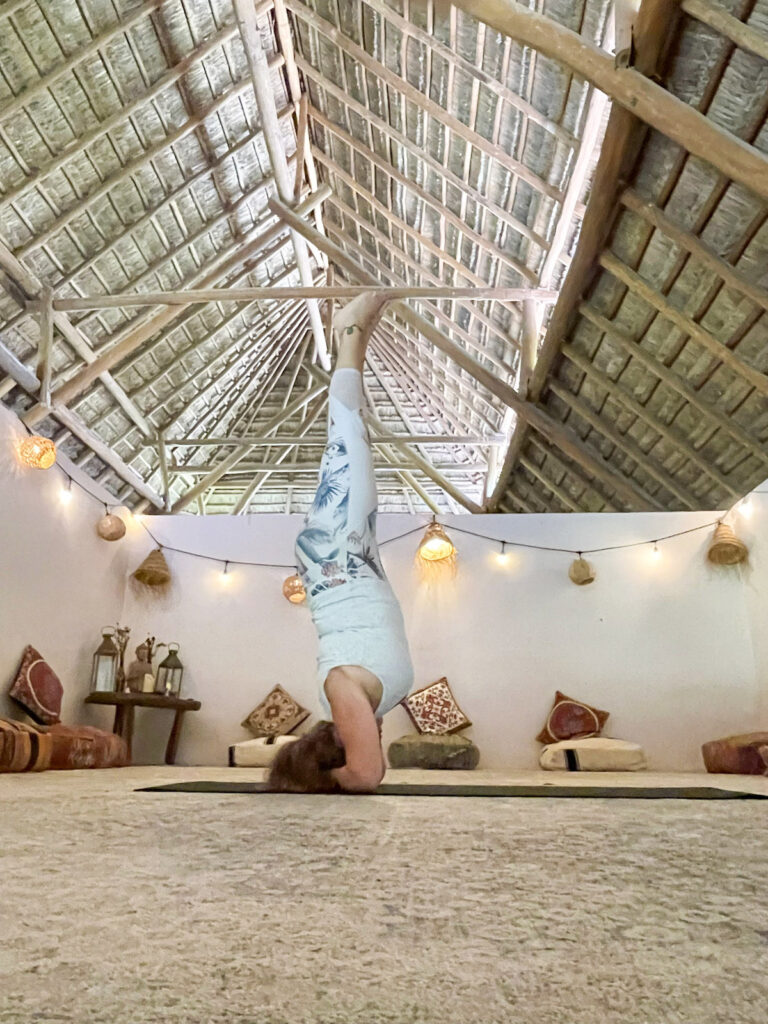 A woman doing a headstand.